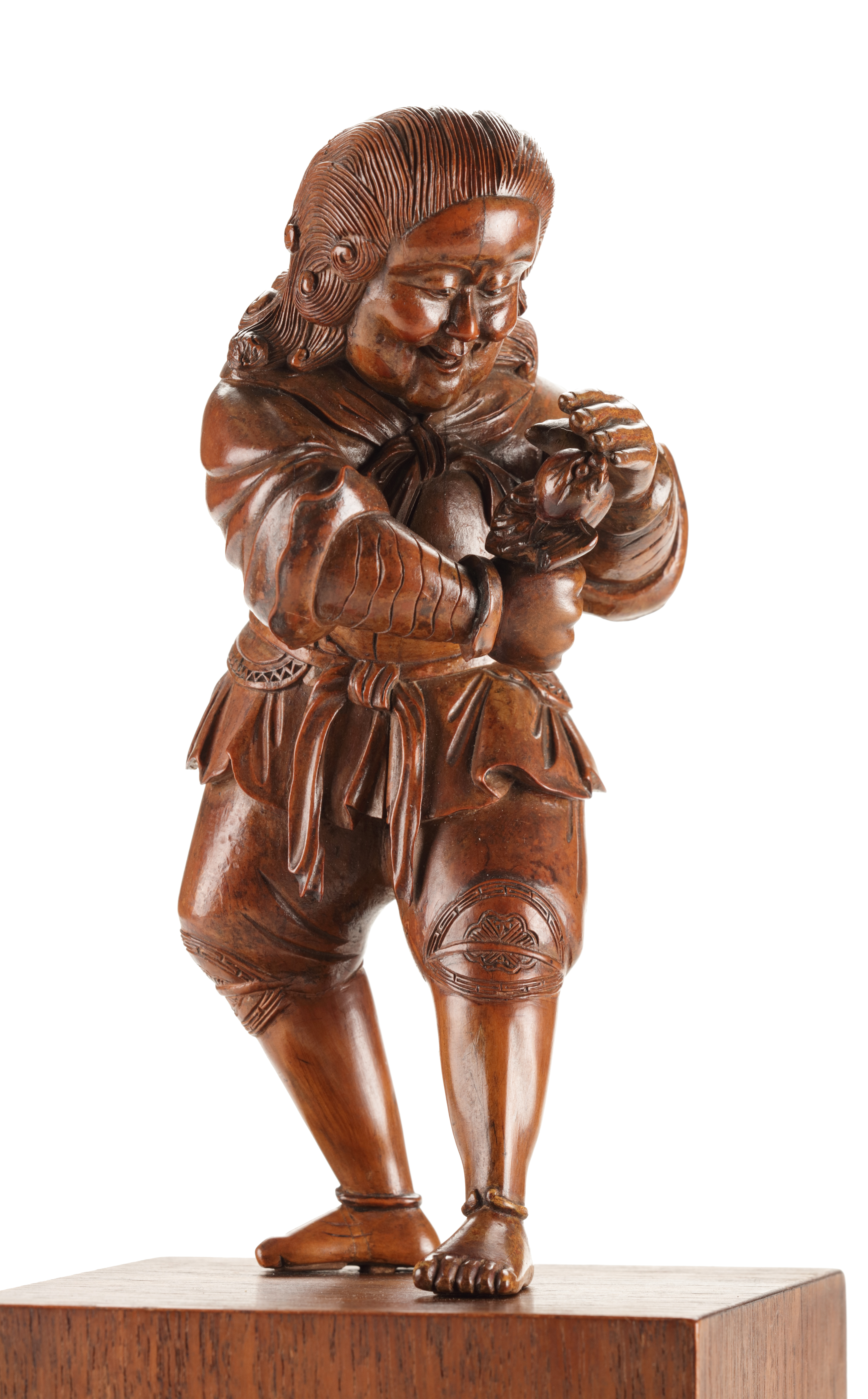 A fine boxwood Japanese okimono of a Dutchman playing with a bat
