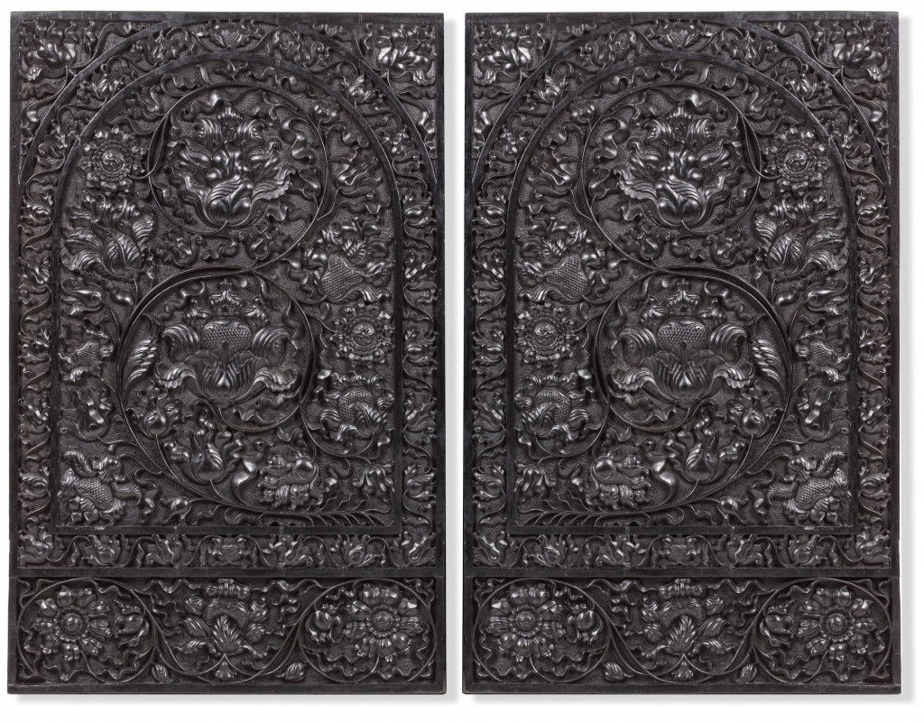 A pair of Indonesian ebony door-panels with bold carvings of leaves and flowers in half-relief