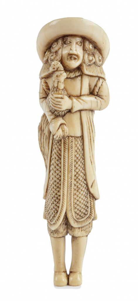 A stag antler netsuke of a Dutchman holding a cockerel