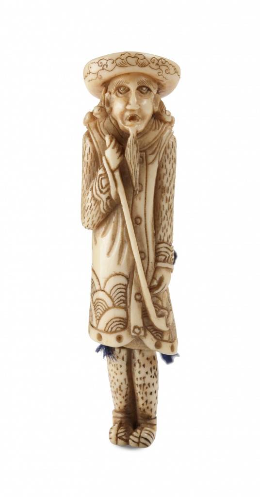A bone netsuke of a Dutchman holding a pipe and having detachable legs