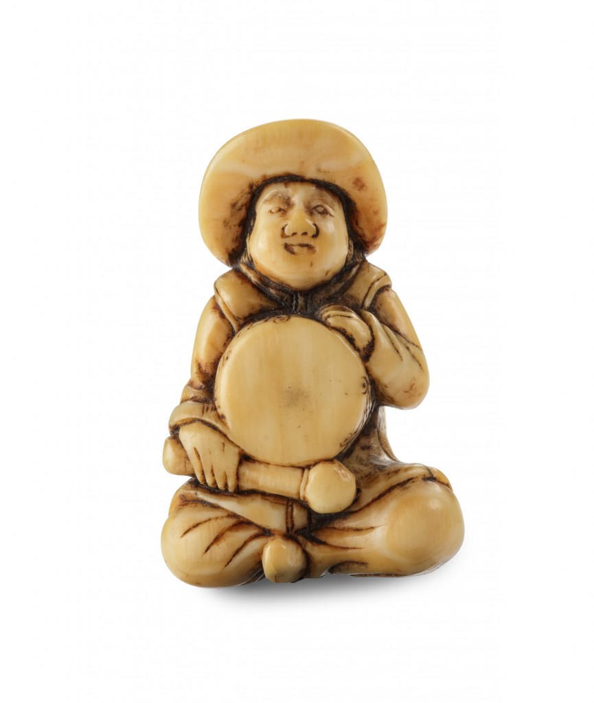 A small ivory netsuke of a Dutchman with a drum