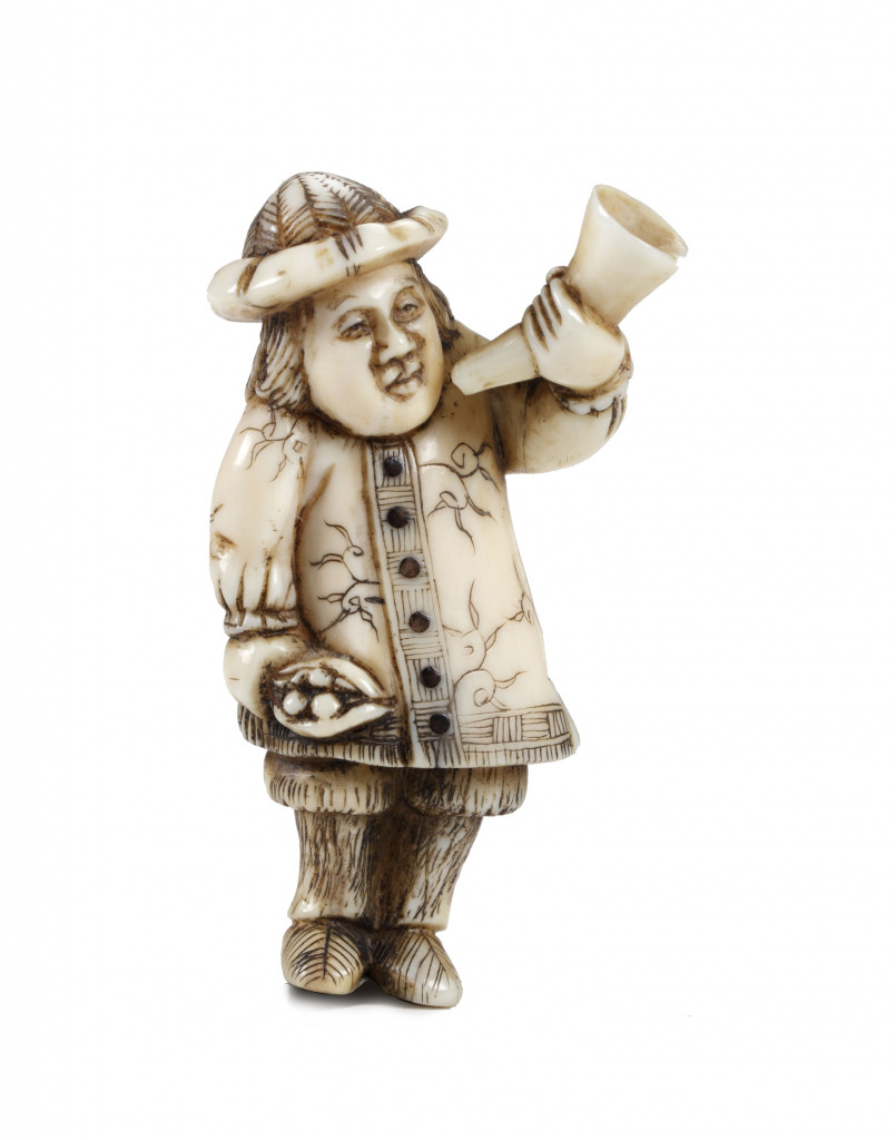 An ivory and black horn netsuke of a Dutchman