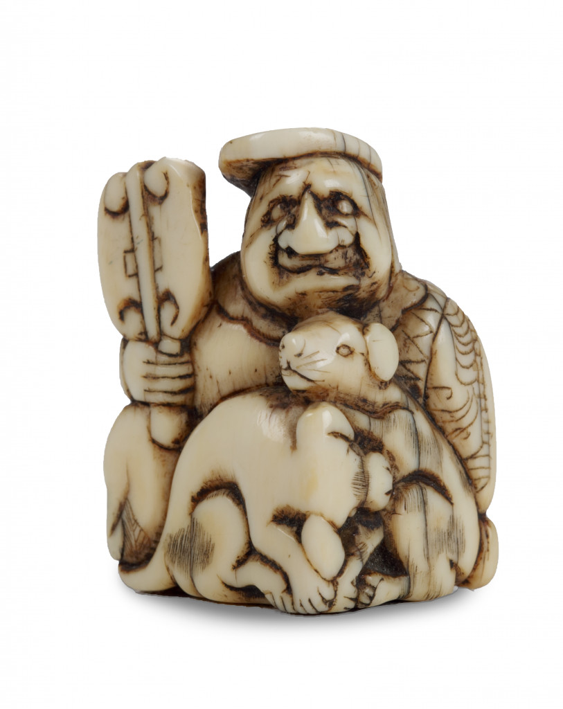 An ivory netsuke of a Dutchman with two dogs
