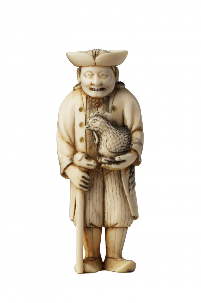 An ivory netsuke of a Dutchman holding a stick and cockerel, signed Yoshiyuki