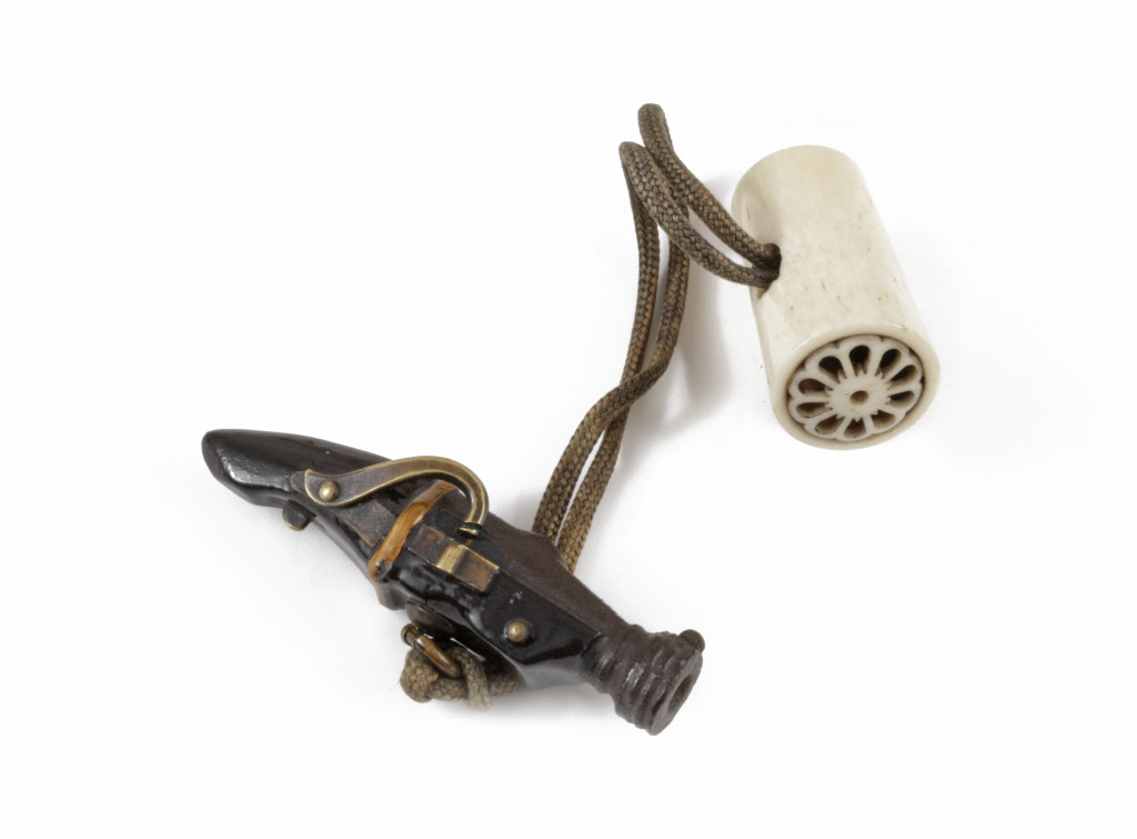 A bronze and bone netsuke of a matchlock pistol