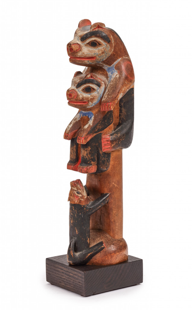 A pigmented wood Tlingit potlatch carving of a wolf chasing two bear cubs up a tree