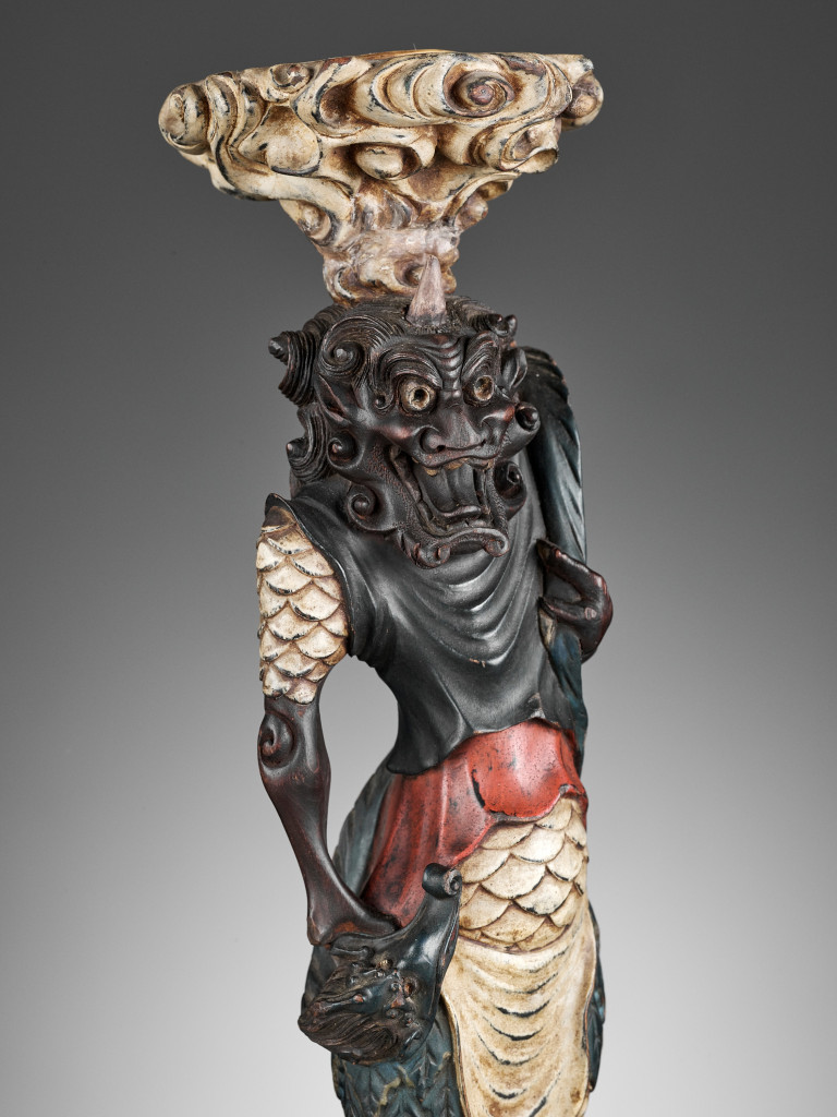 A pair of Japanese painted and lacquered wood candlesticks in the form of oni