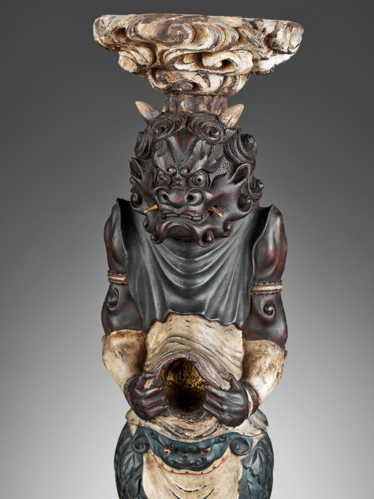 A pair of Japanese painted and lacquered wood candlesticks in the form of oni
