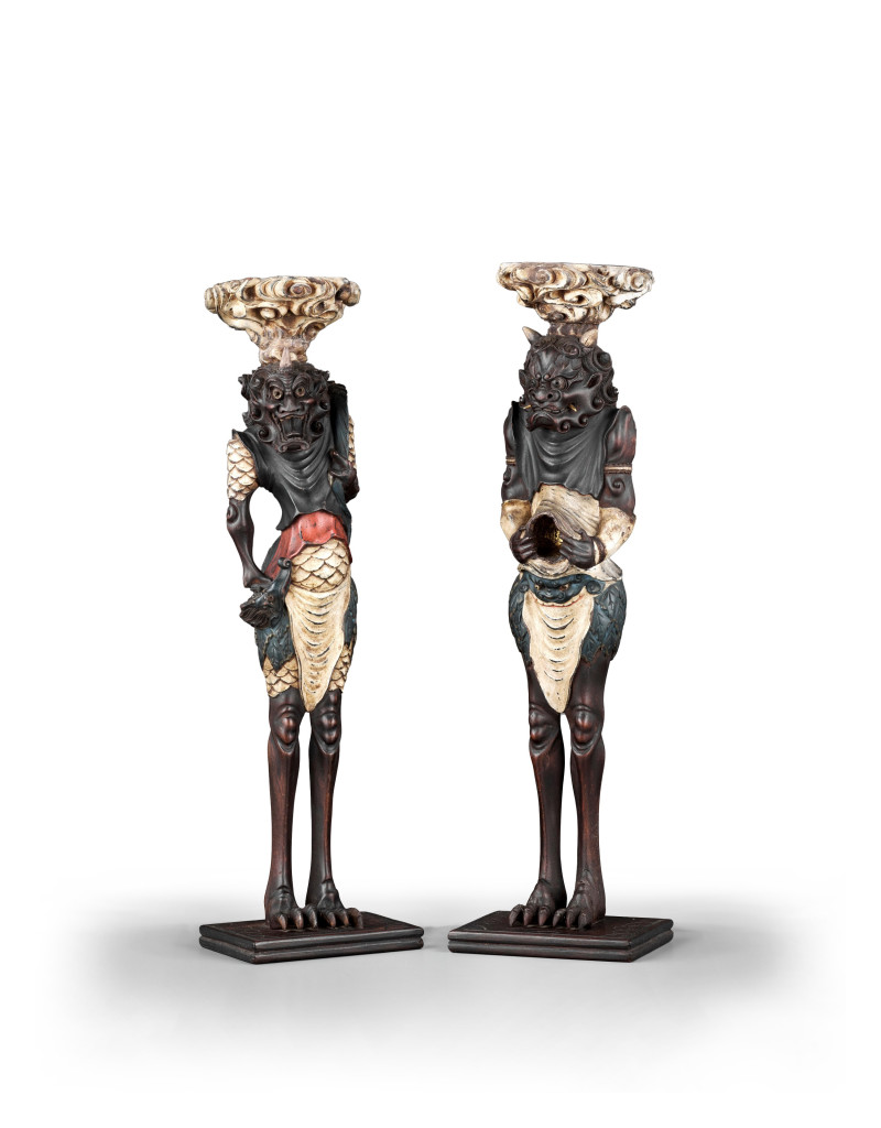 A pair of Japanese painted and lacquered wood candlesticks in the form of oni