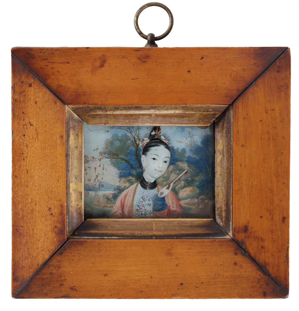 A pair of miniature reverse-glass paintings of ladies in a landscape, in original maple wood frames