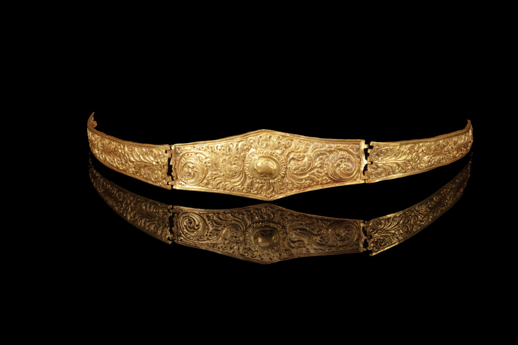 An ancient Javanese royal gold part adornment set for a queen, consisting of a topknot crown with a rock-crystal finial, a breast ornament, a belt, and a pair of gem-set upper-arm bracelets, each in repoussé high-carat gold