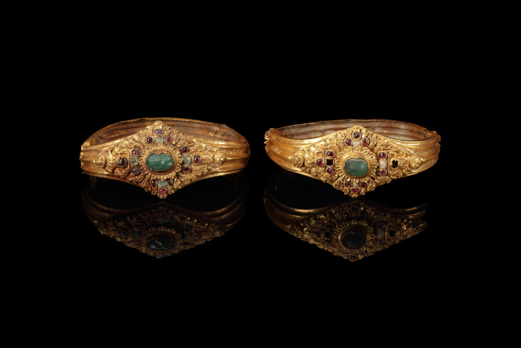 An ancient Javanese royal gold part adornment set for a queen, consisting of a topknot crown with a rock-crystal finial, a breast ornament, a belt, and a pair of gem-set upper-arm bracelets, each in repoussé high-carat gold