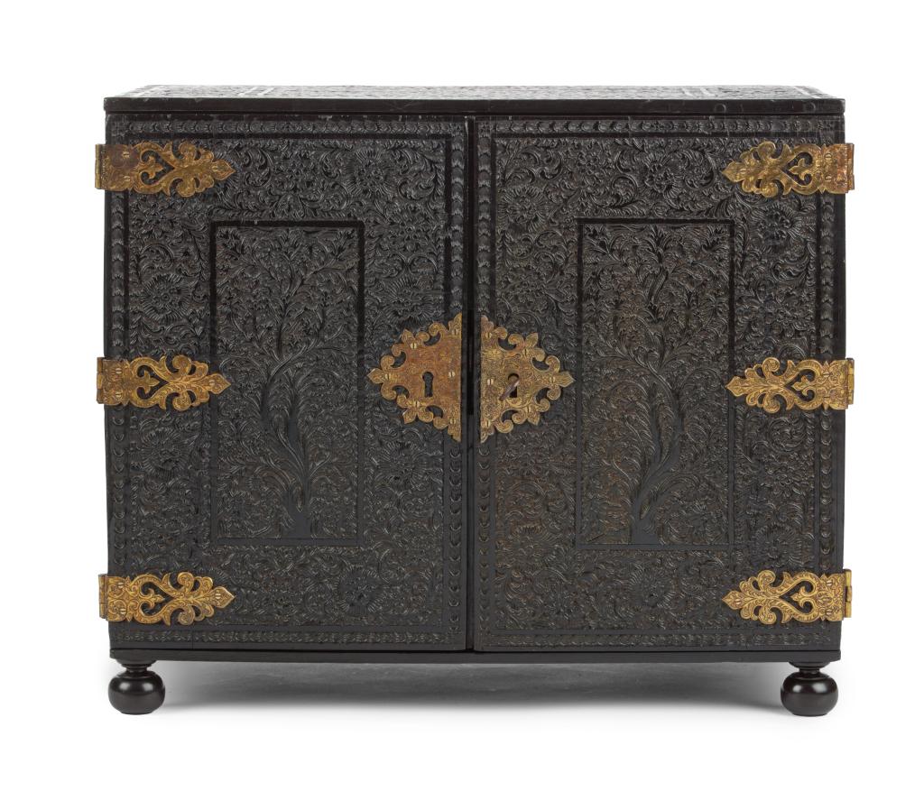 An Indian low-relief carved ebony cabinet with brass mounts