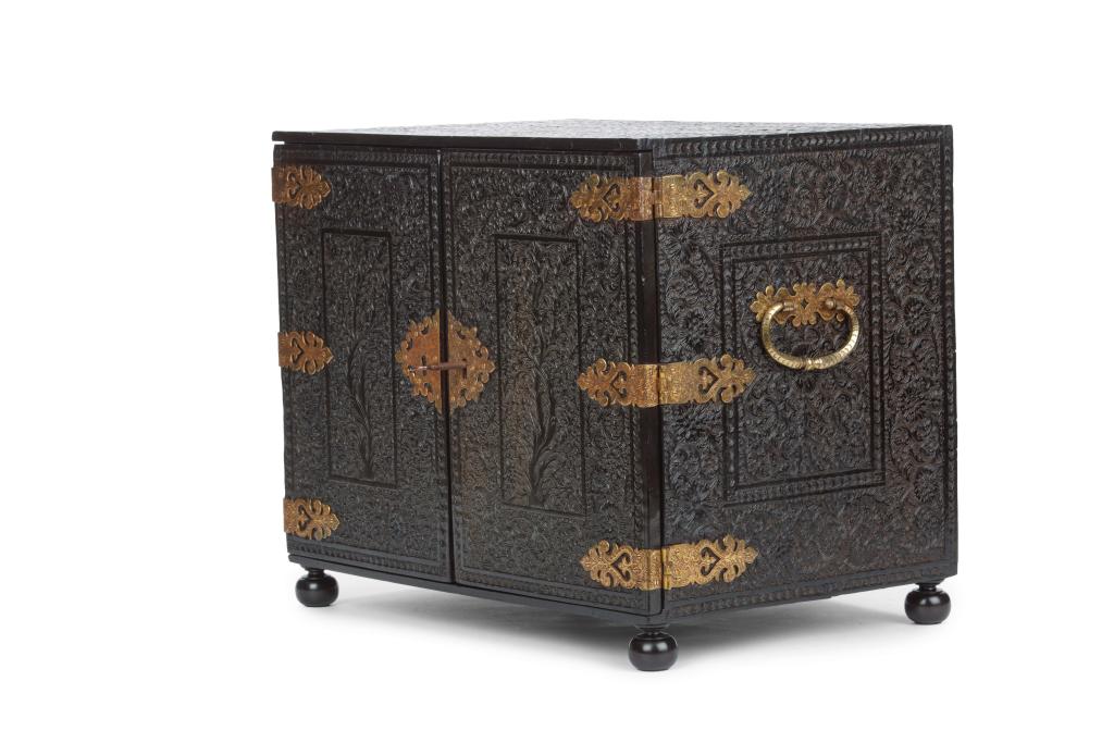 An Indian low-relief carved ebony cabinet with brass mounts