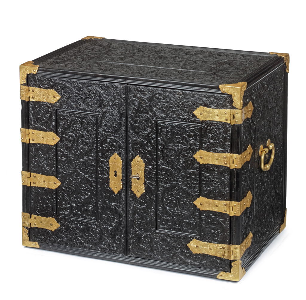 A two-door low-relief carved ebony and ivory cabinet with gilt-brass mounts