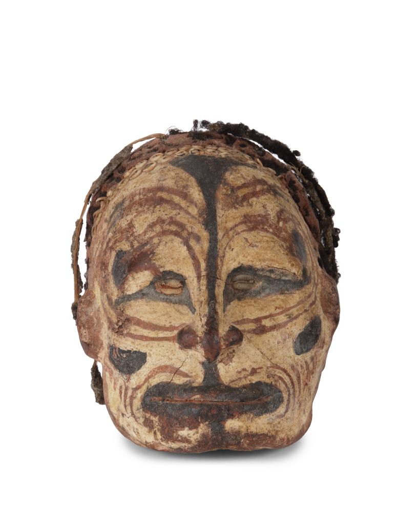 A Sepik shell-and-pigment decorated clay overmodeled ancestral skull