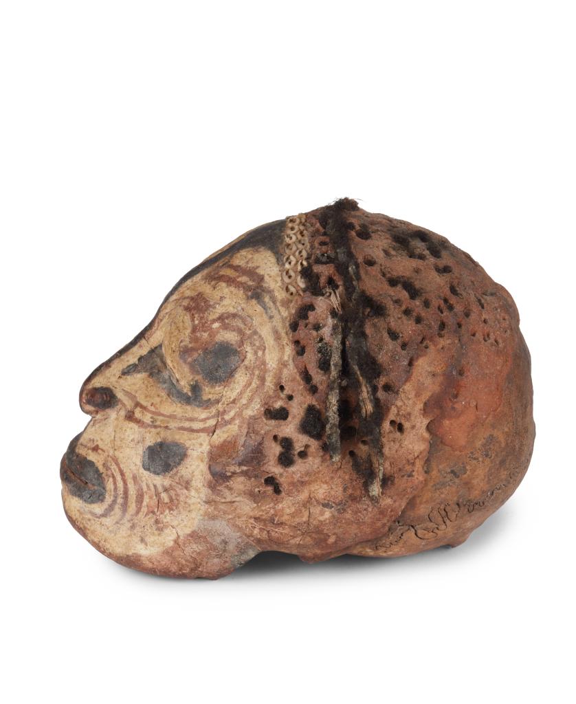 A Sepik shell-and-pigment decorated clay overmodeled ancestral skull