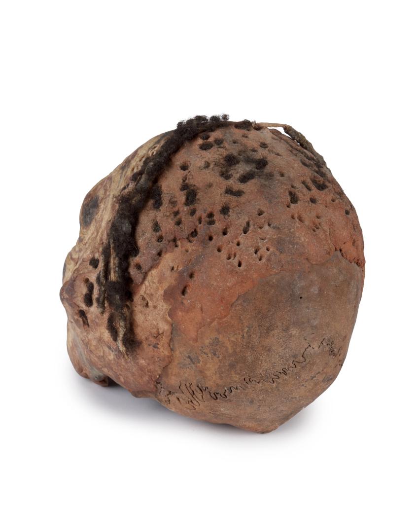 A Sepik shell-and-pigment decorated clay overmodeled ancestral skull