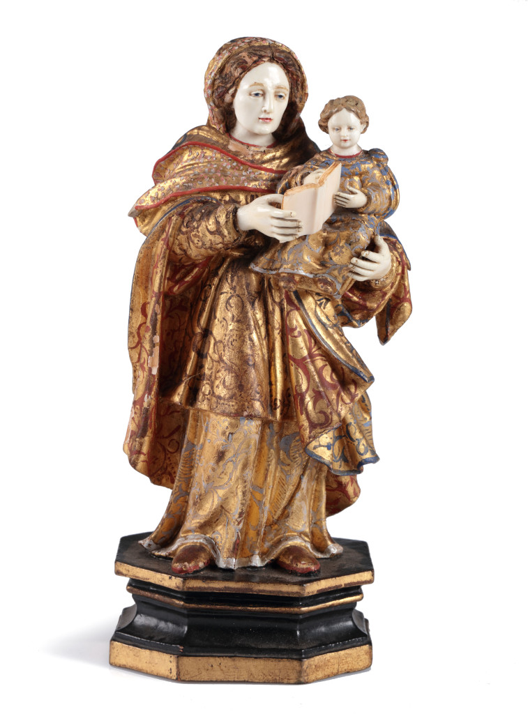 An Indian-Portuguese sculpture of the Holy Virgin holding the child Jesus on her arm, giving him reading lessons