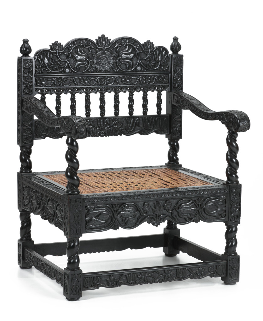 An unusual Indian half-relief carved ebony armchair